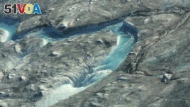 In this image taken on Thursday Aug.1, 2019 large rivers of melting water form on an ice sheet in western Greenland and drain into moulin holes that empty into the ocean from underneath the ice. (Photo via Caspar Haarl<I>&#</I>248;v, Into the Ice via AP)