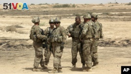 FILE - U.S. soldiers are seen with Iraqi troops, outside Baghdad, Iraq, May 27, 2015. 