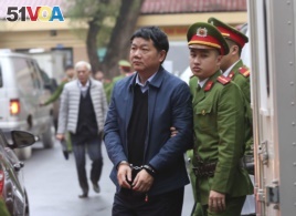 Dinh La Thang, front left, is led into a court room by police in Hanoi, Vietnam, Monday, Jan. 8, 2018.