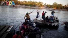 People belonging to a caravan of migrants from Honduras en route to the United States, cross the Suchiate river to Mexico from Tecun Uman, Guatemala, Jan. 18, 2019. 