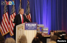 Republican U.S. presidential candidate Donald Trump speaks in front of a display of Trump water, wine and steaks as he talks about the results of the Michigan, Mississippi and other primary elections during a news conference held at his Trump National Gol