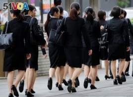 Female office workers wearing high heels, clothes and bags of the same color make their way at a business district in Tokyo, Japan, June 4, 2019. (REUTERS/Kim Kyung-Hoon)