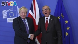 British Prime Minister Boris Johnson shakes hands with European Commission President Jean-Claude Juncker during a press point at EU headquarters in Brussels, Thursday, Oct. 17, 2019. 