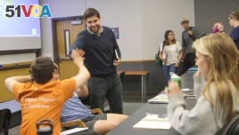 Carlos Galdeano (standing) high fives a student