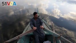 An Egyptian fisherman sits in his boat in the Egyptian Nile Delta province of al-Minufiyah, near the town of Ashmun, March 10, 2017.