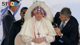 Pope Francis wears a headdress that was gifted to him during a visit with Indigenous peoples at Maskwaci, the former Ermineskin Residential School, Monday, July 25, 2022, in Maskwacis, Alberta. (AP Photo/Eric Gay)