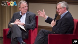 Former President George W. Bush, left, listens to Pulitzer Prize winning author Jon Meacham, right, talk about his biography of Bush's father, former President George H. W. Bush, Sunday, Nov. 8, 2015.
