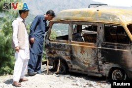 People look at the van in which Ambreen Riasat was burned in the village of Makol outside Abbottabad, Pakistan, May 6, 2016.