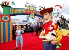 People in costume as Bo Peep, Woody and Forky are seen at the premiere for 