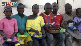 FILE - Children displaced as a result of Boko Haram attacks in the northeast region of Nigeria, eat at a camp for internally displaced persons (IDP) in Yola, Adamawa State, Jan. 13, 2015. 