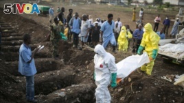 Health workers carry the body of an Ebola victim for burial at a cemetery in Freetown, December 17, 2014. 