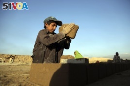 In this Wednesday, June 19, 2019, photo, Kamran, 10, works at a brick factory on the outskirts of Kabul, Afghanistan. Every day before dawn, 10-year-old Kamran goes to work with his father and other relatives at a brick factory on the outskirts of Kabul.