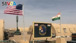 In this photo taken April 16, 2018, a U.S. and Niger flag are raised side by side at the base camp for air forces and other personnel supporting the construction of Niger Air Base 201 in Agadez, Niger.