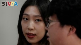 Yoo Young Yi watches her husband Jo Jun Hwi as he speaks during an interview at their home in Seoul, South Korea on October 2, 2022. (AP Photo/Ahn Young-joon)