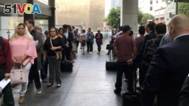 FILE - Immigrants awaiting deportation hearings line up outside the building that houses the immigration courts in Los Angeles, June 19, 2018. (AP Photo/Amy Taxin, File)