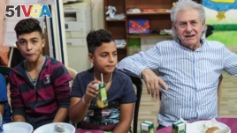 Jibril Latach, 16 and Lebanese, joins his best friend Raed Abdo, 14, a Syrian refugee from Homs, for post-rehearsal food and drinks with maestro Salim Sahab, Oct. 28, 2017, in Tripoli, Lebanon.