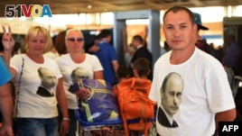 Russian tourists wearing t-shirts bearing a portrait of Russian President Vladimir Putin, queue inside the airport in Egypt's Red Sea resort of Sharm El-Sheikh on Nov. 6, 2015. Russia has halted all flights to Egypt. AFP PHOTO / MOHAMMED EL-SHAHED
