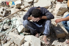 A man reacts on the rubble of damaged buildings after losing relatives to an airstrike in the besieged rebel-held al-Qaterji neighborhood of Aleppo, Syria, Oct. 11, 2016.
