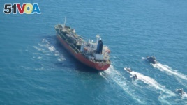 In this photo released Monday, Jan. 4, 2021, by Tasnim News Agency, a seized South Korean-flagged tanker is escorted by Iranian Revolutionary Guard boats on the Persian Gulf. (Tasnim News Agency via AP)