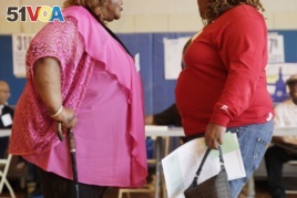 FILE: In this June 26, 2012, photo, two overweight women hold a conversation in New York.