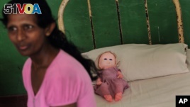 In this 2013 file photo, a resident of Half Way Home, a home for the mentally ill, sits on her bed in Mulleriyawa, on the outskirts of Colombo, Sri Lanka, 