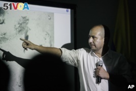Ernesto Montenegro is director of the Colombian Institute of Anthropology and History of Colombia. Here, he talks to reporters while he shows a picture of remains of the galleon San Jose in Cartagena, Colombia, Dec.5, 2015.