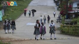 Wearing masks to curb the spread of the new coronavirus, students walk to the one open school in Campohermoso, Colombia, Thursday, March 18, 2021. (AP Photo/Fernando Vergara)