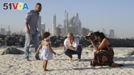 Freelance lifestyle photographer, Paula Hainey, takes photos of Darrin Chapman, a pilot recently laid off by long-haul carrier Emirates, his wife, Jodi Chapman, and their daughter Harper, in Dubai, United Arab Emirates, Wednesday, Oct. 14, 2020. Hainey is
