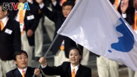 North Korea's Jang Choo Pak (L) and South Korea's Eun-Soon Chung carry a flag bearing the unification symbol of the Korean peninsula during the opening ceremony of the Sydney 2000 Olympic Games.