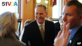 File Photo - South Dakota Gov. Dennis Daugaard greets Secretary of State Shantel Krebs, left, shortly before giving his State of the State address to the South Dakota Legislature, Tuesday, Jan. 12, 2016, at the state Capitol in Pierre, S.D. (AP Photo/James Nord)