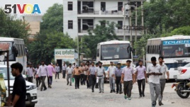 印度工人行走在北部哈里亚纳邦的铃木汽车制造工厂旁的街道上（2019年8月2日）