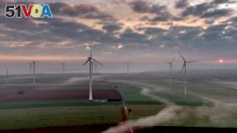 FILE - Wind turbines operate at an energy plant near Stetten, north of Kaiserslautern, Germany, as the sun rises on, March 19, 2024. According to a new report published Tuesday, April 16, 2024, last year, marked the best year for new wind projects. (AP Photo/Michael Probst, File)