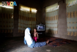 Nadra holds her eight-month-old child Muhammad Ali, in their living room in Zanzibar City, Tanzania, February 3, 2019. Nadra took Muhammad to a traditional healer, Bi Mwanahija Mzee, to seek relief for her child suffering from an umbilical hernia.