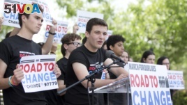 Cameron Kasky, center, speaks during a news conference, Monday, June 4, 2018, in Parkland, Florida, one day after graduating from high school. His group has announced a bus tour to 