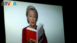 Hillary Clinton seen on a monitor at the Grammy Awards reading from the book, 