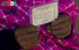 117-year-old Julia Flores Colque holds her identification card displaying her date of birth in Sacaba, Bolivia.