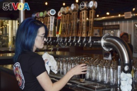 Maya Martinez, a manager at the Rio Bravo Brewing Company in Albuquerque, N.M., pours a craft beer, May 3, 2017, just days before the brewery was set to unveil a new beer on Cinco de Mayo.