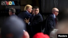 Secret Service agents surround U.S. Republican presidential candidate Donald Trump during a disturbance as he speaks at Dayton International Airport in Dayton, Ohio, March 12, 2016. (REUTERS/Aaron P. Bernstein)