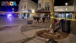 Police walk along the streets in downtown Waukesha, Wis., after a vehicle crashed into a Christmas parade Sunday, Nov. 21, 2021. (AP Photo/Jeffrey Phelps)