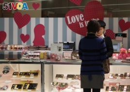 A woman buys Valentine's Day chocolates at a store in Tokyo Tuesday, Feb. 14, 2012. (AP Photo/Shizuo Kambayashi)