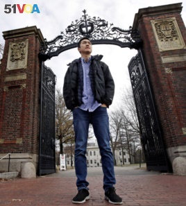 Harvard University graduate Jin K. Park, who holds a degree in molecular and cellular biology, poses at a gate at Harvard Yard in Cambridge, Mass., Thursday, Dec. 13, 2018. (AP Photo/Charles Krupa)