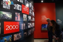 People visit the Pulitzer Prize Photography exhibition at the Newseum, Friday, Dec. 20, 2019, in Washington. (AP Photo/Jacquelyn Martin)