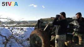 A Free Syrian Army fighter uses binoculars near the Menagh military airport, in Aleppo's countryside, Syria, January 10, 2013.