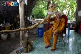 Nguyen Van Chien, 92, sits for a portrait to show his 5-meter long hair which according to him, has not been cut for nearly 80 years, at his home in Tien Giang province, Vietnam, August 21, 2020.