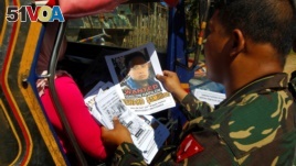 FILE - Soldiers distribute pictures of a member of extremist group Abu Sayyaf, Isnilon Hapilon, who has a U.S. government bounty of $5 million for his capture, in Butig, Lanao del Sur in southern Philippines, Feb. 1, 2017. (REUTERS/Marconi B. Navales)