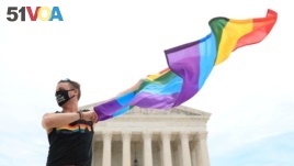 Joseph Fons holding a Pride Flag, stands in front of the U.S. Supreme Court building after the court ruled that a federal law banning workplace discrimination also covers sexual orientation, in Washington, D.C., U.S., June 15, 2020.