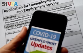 FILE - In this photo illustration, a COVID-19 Unemployment Assistance Updates logo is displayed on a smartphone on top of an application for unemployment benefits on May 8, 2020, in Arlington, Virginia.