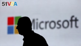 FILE - A man is silhouetted as he walks in front of a Microsoft logo Nov. 7, 2017. Microsoft says it has uncovered new Russian hacking attempts targeting U.S. political groups ahead of midterm elections in November. (AP Photo/Altaf Qadri, File)