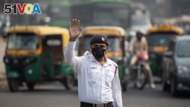 FILE - A traffic policeman wears a mask to protect himself from air pollution at a junction during restrictions on private vehicles based on registration plates, on a smoggy morning in New Delhi, India, November 4, 2019. (REUTERS/Danish Siddiqui)