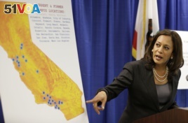 In this March 24, 2016 photo, then-California Attorney General Kamala Harris points to an image showing the location of Corinthian Colleges located in California during a news conference in San Francisco.
